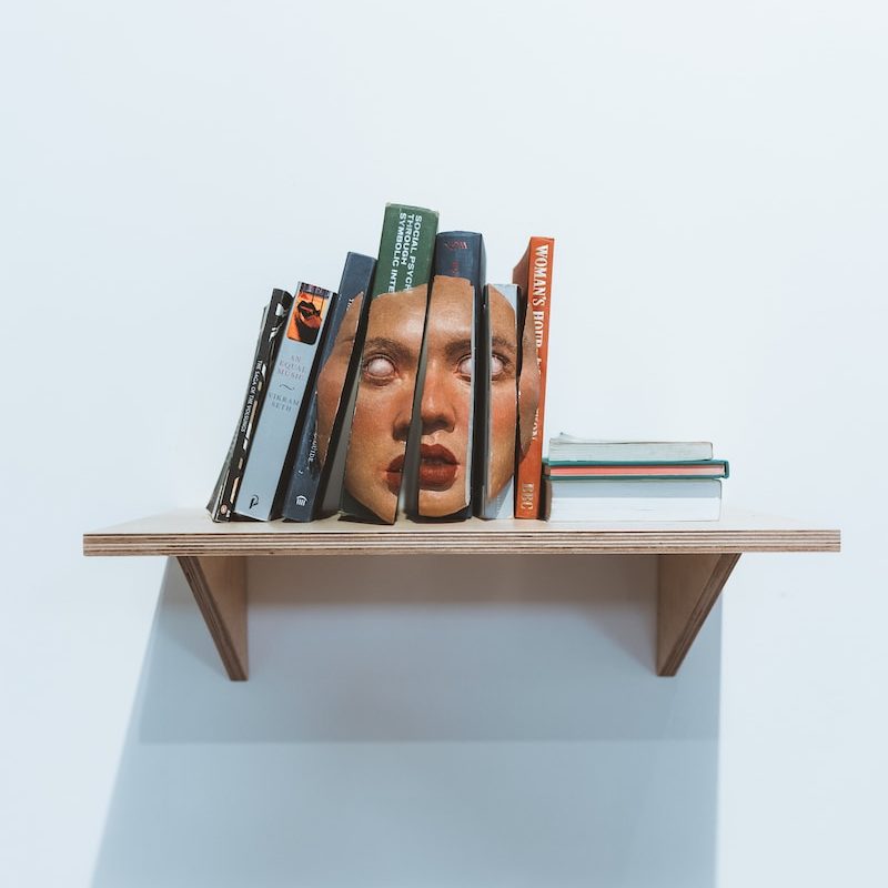 a shelf with books and pens on it